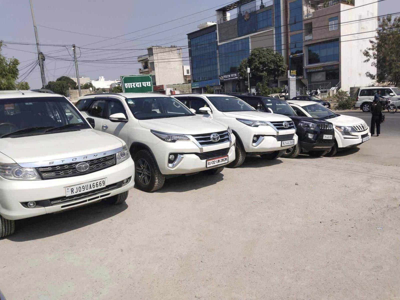 White SUVs including a Toyota Fortuner, Tata Safari Storme and Mahindra XUV500 lined up on the Car Junction lot